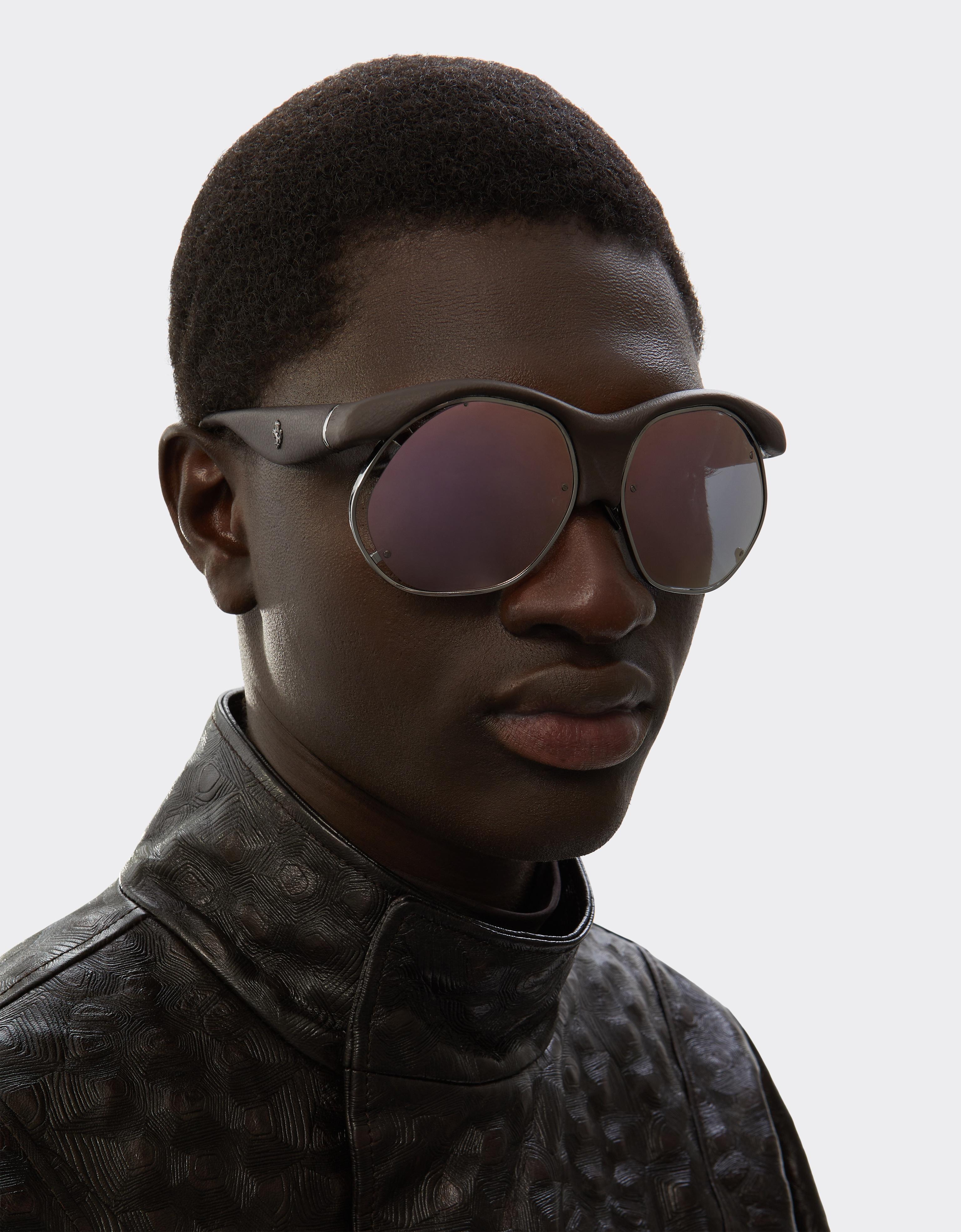 Injection-moulded sunglasses in metal and dark brown leather with grey lenses featuring a pink mirror finish
